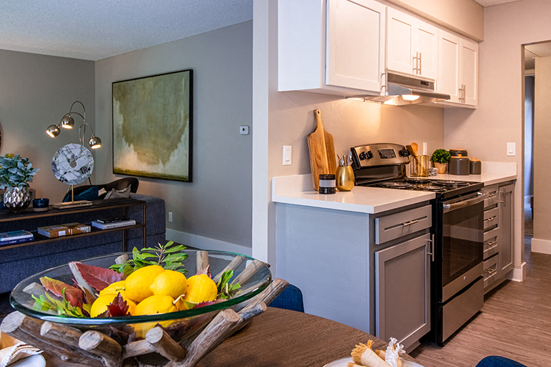 a kitchen and living room with a bowl of fruit on a table